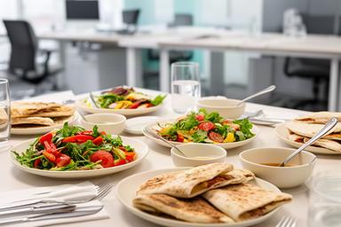 Light lunch con insalate e piadine disposto in un ufficio veronese